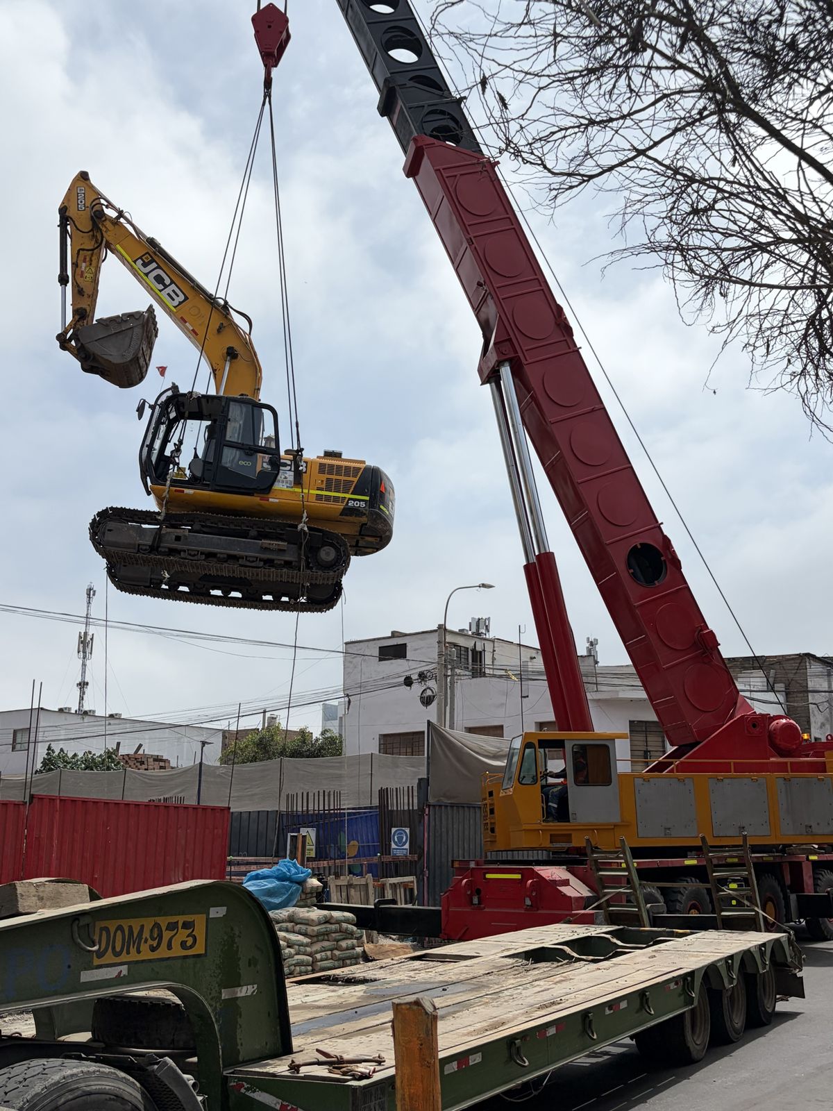 Grúa de Ememca izando una excavadora JCB 205 sobre orugas